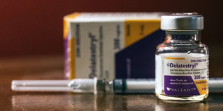 Delatestryl© Ampulle vor einer liegendenden, unbenutzen Spritze und der liegenden Delatestryl© Verpackung