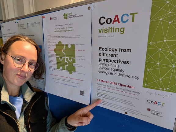 Dr. Patch points to her name on the colloquium flyer