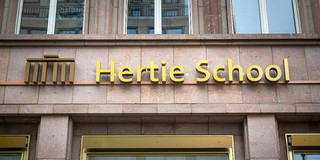 Logo über einem Eingang: metallisches Brandenburger Tor und Hertie School